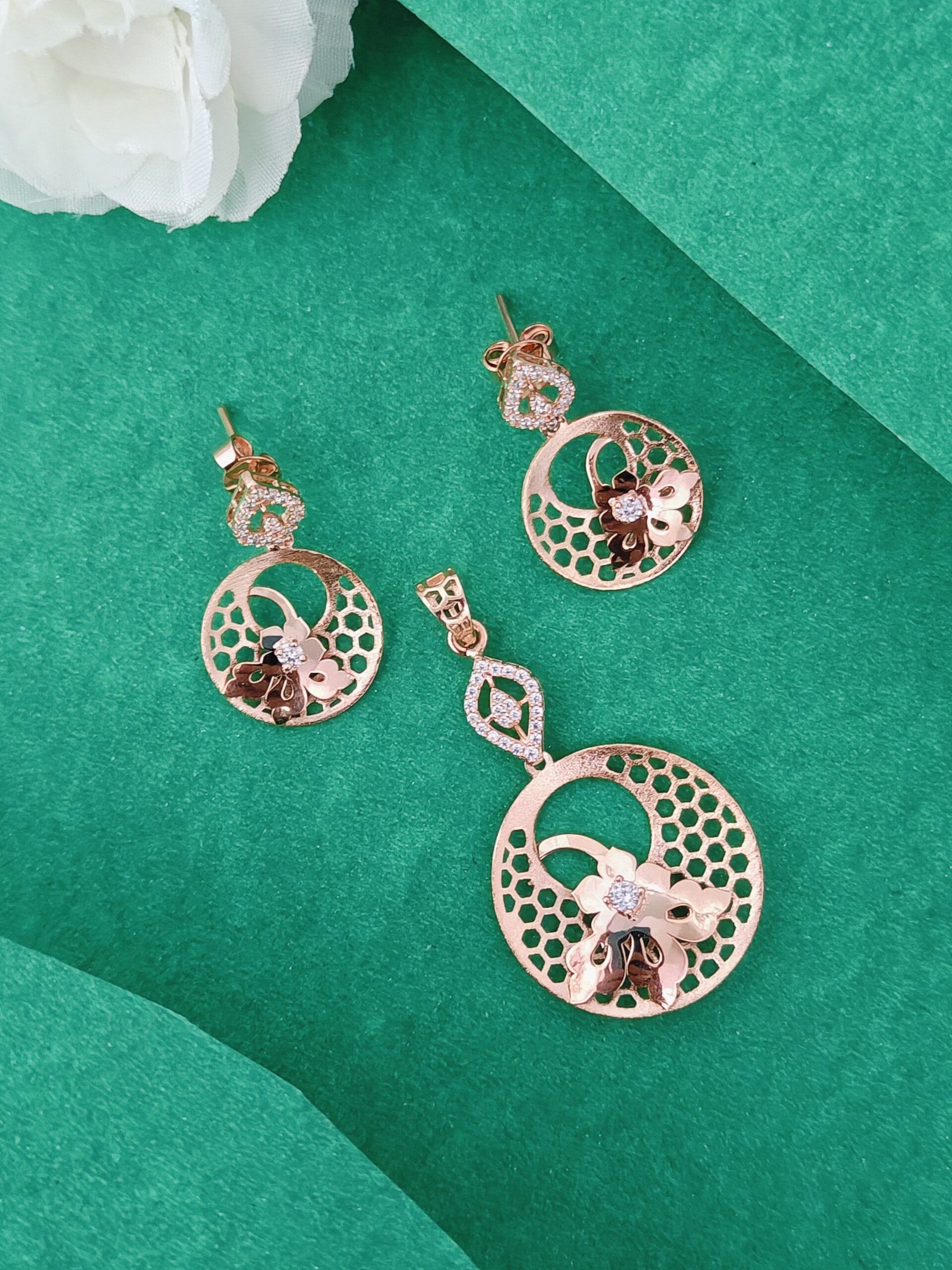 Rose gold earrings on a green background